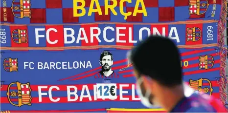  ?? EFE ?? Bufandas del Barça en las que se ve el rostro de Messi, a la venta cerca del Camp Nou