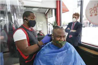  ?? NICOLAuS CzARnECkI / hERALD STAFF ?? LISTENING TOUR: U.S. Rep. Joseph Kennedy III talks with barber Angel Ramirez and client Edward Garcia at Blue Hill Barbers on Wednesday as he starts a tour of the state to get input on a coronaviru­s work relief plan.