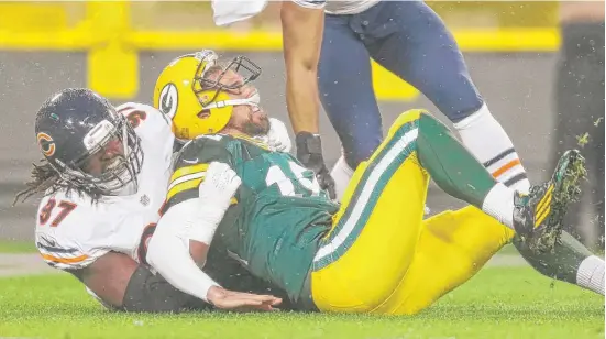  ??  ?? Willie Young lays a hit on the Packers’ Aaron Rodgers in the Bears’ victory at Lambeau Field. Young warns it is too early for the Bears to be thinking about the playoffs.