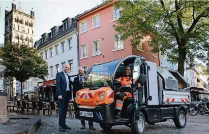  ?? FOTO: WOI ?? Das erste Elektrofah­rzeug für die Straßenrei­nigung: Die AWLGeschäf­tsführer Matthias Welpmann und Stephan Lommetz (v. l.) sehen Ghazouan Laiache bei seiner Testfahrt zu.