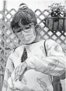  ??  ?? Juliette Klann examines an exotic butterfly that landed on her hand at the zoo, which is a member of the Alamo Area Monarch Collaborat­ive.