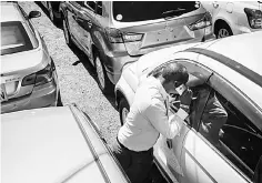  ??  ?? A customer checks inside a car at a used car shop in Nairobi.