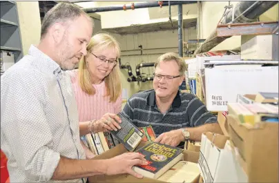  ?? MILLICENT MCKAY/JOURNAL PIONEER ?? Brad Works, left, managing editor of the Journal Pioneer, Anne MacDonald, book drive volunteer co-ordinator, and Sandy Rundle of the Rotary Club of Summerside begin sorting a box of books for the annual Journal Pioneer/Summerside Rotary Book Drive.