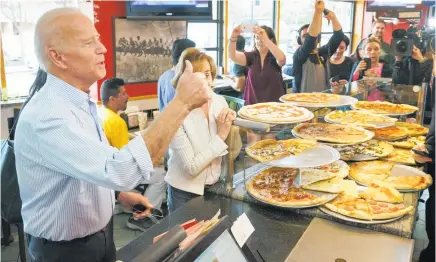  ?? Photo / AP ?? Joe Biden let the staff at Gianni’s Pizza in Wilmington, Delaware, know that he wants a slice of the action yesterday.