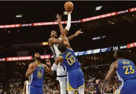  ?? Brandon Dill / Associated Press ?? Grizzlies forward Jaren Jackson Jr. shoots over Warriors forward Jonathan Kuminga, a rookie who could develop into a rival for many years to comes.