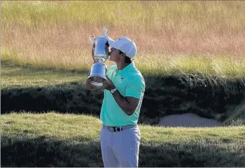  ?? CHRIS CARLSON/AP ?? Winner Brooks Koepka kisses his first major trophy Sunday amid the scenery of first-time U.S. Open host Erin Hills.