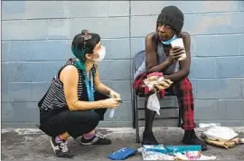  ?? Mel Melcon Los Angeles Times ?? CIARA DeVOZZA, left, of the People Concern waits with Janice Johnson for the results of a rapid test used to detect diseases in downtown L.A. last month.