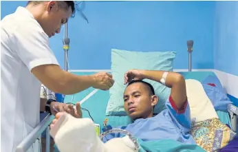  ??  ?? BACK FROM THE FRONT: A wounded soldier on his hospital bed being treated for a shattered leg from combat with militants in Marawi, in the Armed Forces of the Philippine­s Medical Center in Manila.