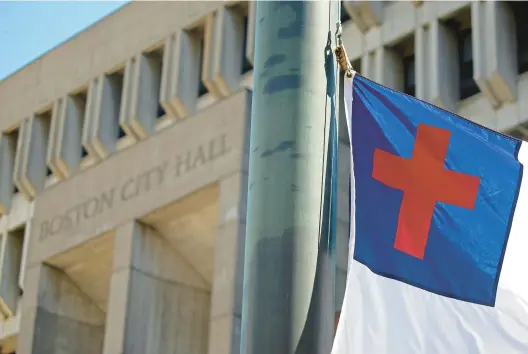  ?? STUART CAHILL/BOSTON HERALD VIA AP ?? The Christian flag is raised at City Hall Plaza on Aug. 3, 2022, in Boston. The Christian flag that became the focus of a free speech legal battle that went all the way to the Supreme Court was raised outside Boston City Hall to cheers and songs of praise.