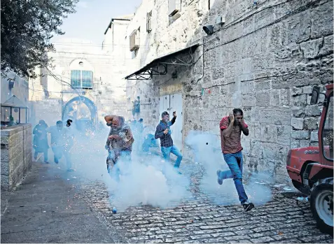  ??  ?? Tear gas thrown by Israeli police in more clashes with Palestinia­ns after the removal of barriers at Jerusalem’s al-aqsa mosque compound, right