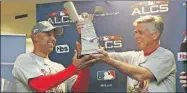  ??  ?? Dave Dombrowski, gerente de los Medias Rojas, entrega a Alex Cora, el trofeo de campeones de la Liga Americana, ganado en Houston