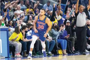  ?? AP Photo/Jeff Chiu ?? ■ Golden State Warriors guard Stephen Curry (30) reacts Friday in front of fans after shooting a 3-point basket against the Phoenix Suns during the first half of an NBA basketball game in San Francisco.