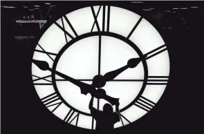  ?? ELISE AMENDOLA/AP, FILE ?? Electric Time technician Dan Lamoore puts a clock hand onto a 1,000-pound, 12-foot clock constructe­d in Medfield, Mass., for a resort in Vietnam on March 9, 2021. Daylight saving time this year starts at 2 a.m. Sunday, March 12.