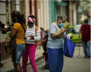  ?? AFP. ?? Mujeres cubanas compran comida en una calle de La Habana. Las protestas han disminuido desde el domingo.