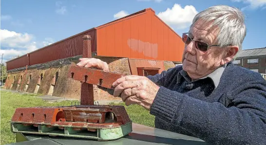  ?? WARWICK SMITH/STUFF ?? Hoffman Kiln trustee David Chapple examines the rediscover­ed model, showing how it worked to fire the bricks for many Palmerston North buildings.