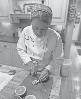  ?? KRISTINE M. KIERZEK ?? Chef Janice Thomas, owner of Savory Spoon Cooking School, cuts garnishes for a recipe.