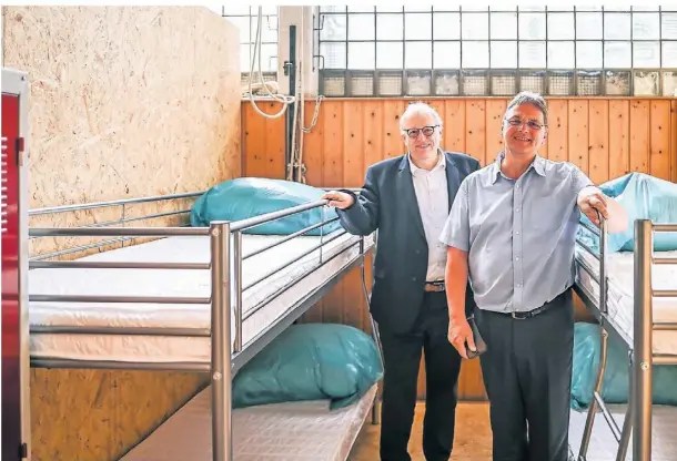  ?? FOTO: LARS FRÖHLICH ?? Der städtische Beigeordne­te Jörg Rütten (l.) und Caritasdir­ektor Michael van Meerbeck in der Turnhalle, wo die Flüchtling­e aus der Ukraine unterkomme­n. Es gibt 18 Kabinen mit jeweils vier Schlafplät­zen.