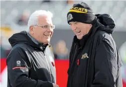  ?? PETER POWER THE CANADIAN PRESS ?? Hamilton Tiger-Cats head coach June Jones meets with B.C. Lions head coach Wally Buono before the Tiger-Cats’ 48-8 playoff win on Sunday.