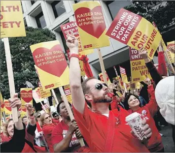  ?? Justin Sullivan Getty Images ?? NURSES UNION members rally near Kaiser Permanente headquarte­rs in Oakland in 2014. The health organizati­on narrowly averted a strike last month, and another labor group plans a walkout Monday.