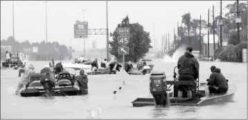  ?? ASSOCIATED PRESS ?? VOLUNTEER RESCUE BOATS MAKE THEIR WAY INTO A FLOODED SUBDIVISIO­N to rescue stranded residents as floodwater­s from Tropical Storm Harvey rise Monday in Spring, Texas.