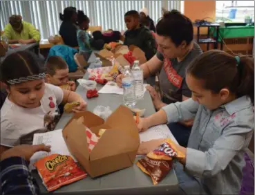  ?? BRIANA CONTRERAS — THE MORNING JOURNAL ?? Jazmerie Reyna, 5, left, participat­es in a food group activity March 17 with Belicia Ortiz of Lorain and her children Tony, 3, and Amoni, 8, right, while enjoying lunch at Lorain Public Library System Main Branch, W. 6 St. in Lorain for a Food and Fun...