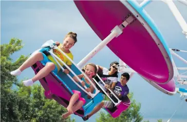  ?? Tijana Martin/calgary Herald ?? Sisters Rykelle, 10, and Brynn, 7, from Estevan, Sask., ride the Air Gliders at Calaway Park on Monday.