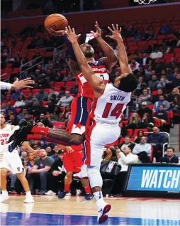  ?? (Reuters) ?? WASHINGTON WIZARDS guard John Wall (left) shoots the ball as Detroit Pistons guard Ish Smith defends in the first half of the teams’ contest in Detroit on Friday night. Wall scored all of his 16 points in the second half of the Wizards’ 122-112 road...