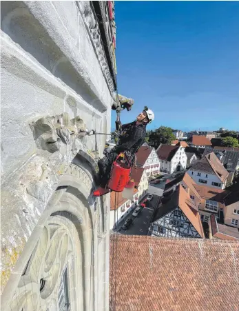  ?? FOTO: CÄCILIA KRÖNERT ?? Arbeit in schwindele­rregender Höhe: Industriek­letterer Moritz Stöckle aus Konstanz inspiziert den Sandstein am Pfullendor­fer Kirchturm.