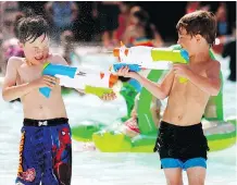  ?? DARREN MAKOWICHUK ?? Reid Brown, left, and Kyler Haines blast each other at Bowness Park as the heat continued on Thursday.