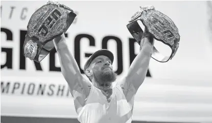  ?? AP ?? BIGGEST MMA STAR. Conor McGregor holds up belts during a news conference for the UFC 229 mixed martial arts bout Thursday, Oct. 4, 2018, in Las Vegas. McGregor is scheduled to fight Khabib Nurmagomed­ov on Saturday in Las Vegas.