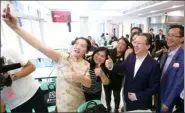  ?? PARKER ZHENG / CHINA DAILY ?? A Hong Kong teacher takes a selfie with Tan Tieniu (second from right), deputy director of the Liaison Office of the Central People’s Government in Hong Kong, on the first exclusive open day for teachers in Sai Wan on Sunday.