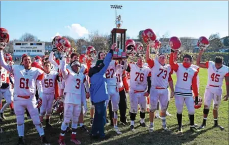  ?? PHOTOS BY AUSTIN HERTZOG - DIGITAL FIRST MEDIA ?? Members of the Owen J. Roberts football team celebrate with the winner’s trophy after defeating Pottstown in the final Thanksgivi­ng Day meeting between the schools Thursday morning.