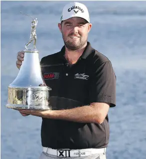  ?? — GETTY IMAGES ?? Marc Leishman of Australia celebrates with the winner’s trophy on the 18th green after winning the Arnold Palmer Invitation­al by a stroke in Orlando, Fla., on Sunday.