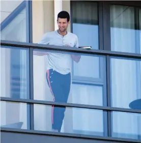  ??  ?? Serbia's Novak Djokovic stands on the balcony at his accommodat­ion in Adelaide, Australia, yesterday