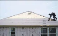  ?? Associated Press file photo ?? A constructi­on worker puts down roofing paper on a new home as he works outside in Houston in July. On Tuesday, the Commerce Department reported on U.S. home constructi­on in October.