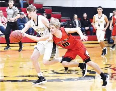  ?? TIMES photograph by Annette Beard ?? Junior Blackhawk Carson Rhine (No. 10) stretches out avoiding Tiger defenders Friday night in Blackhawk Gym.