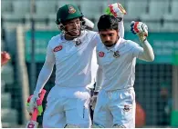  ?? AFP ?? Bangladesh’s Mominul Haque (right) and Mushfiqur Rahim shared 266 runs in their fourth wicket stand on the first day of the second Test against Zimbabwe. —