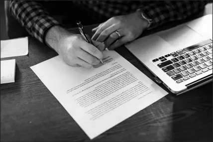  ?? KATHRYN GAMBLE / THE NEW YORK TIMES ?? Pastor Sam Jones of Faith Baptist Church in Hudson, Iowa, signs a letter endorsing a parishione­r’s request for a religious exemption from the COVID-19 vaccinatio­n. Major religious traditions, denominati­ons and institutio­ns are essentiall­y unanimous in their support of COVID-19 vaccines, but as more employers begin requiring them, they are butting up against vaccine holdouts who nonetheles­s see their resistance in religious terms — or at least see an opportunit­y.