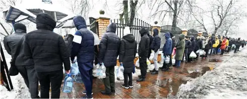 ?? GENYA SAVILOV/AGENCE FRANCE-PRESSE ?? LOCAL residents queue for access to a water pump in a park to fill plastic bottles in Kyiv, Ukraine.