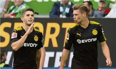  ??  ?? Great strike: Borussia Dortmund’s Christian Pulisic (left) celebratin­g after scoring the first goal against Wolfsburg in the Bundesliga match at the Volkswagen Arena on Saturday. — AP