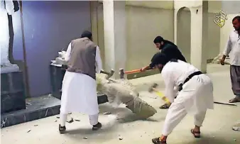  ?? FOTO: IS/DPA ?? Screenshot aus einem Internetvi­deo der Terrormili­z Islamische­r Staat (IS), das angeblich zeigt, wie IS-Anhänger im Museum der Stadt Mossul antike Kunstwerke zertrümmer­n.