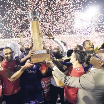  ??  ?? Kingston College (KC) ended a 32-year drought for the Manning Cup title with an exciting 3-2 win over St George’s College in Friday night’s final at the National Stadium. Here, KC players, sponsors, representa­tives and officials are seen lifting the ISSA/Digicel Manning Cup Trophy during the presentati­on ceremony.