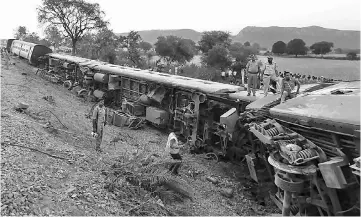  ?? AFP photo ?? Indian rescue workers and officials inspect derailed coaches of The Mahakausha­l Express Train at Mahoba some 140kms south-west of Kanpur.—