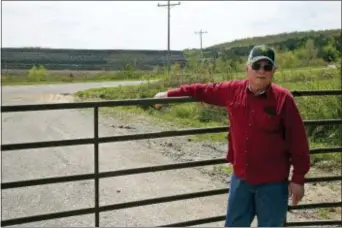  ?? SUE OGROCKI — THE ASSOCIATED PRESS ?? In this photo, Tim Tanksley, who has been fighting for years trying to convince Oklahoma lawmakers to crack down on the coal ash dumping, stands outside a dump site in Bokoshe, Okla.