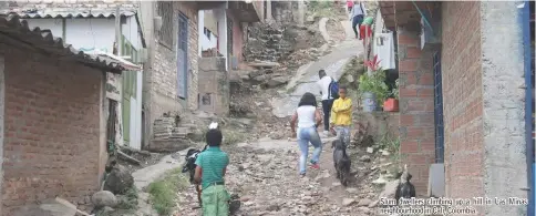  ??  ?? Slum dwellers climbing up a hill in Las Minas neighbourh­ood in Cali, Colombia.