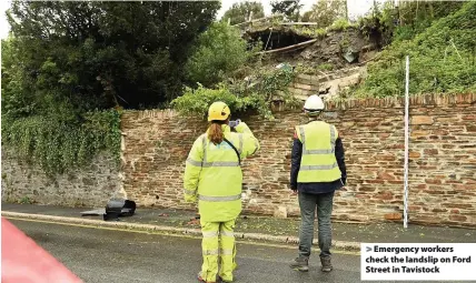 ??  ?? > Emergency workers check the landslip on Ford Street in Tavistock