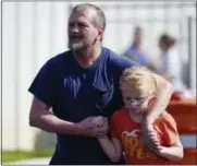 ?? RAINIER EHRHARDT — THE ASSOCIATED PRESS ?? Joey Taylor walks with his daughter Josie Taylor after picking her up at Oakdale Baptist Church on Wednesday in Townville, S.C. Students were evacuated to the church following a shooting at Townville Elementary School. A teenager opened fire at the...