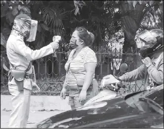  ?? Geremy Pintolo ?? A guard in Intramuros checks people who pass through the walled city’s premises yesterday on the first day of the general community quarantine.