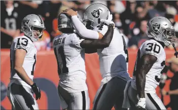  ?? AP PHOTO/JACK DEMPSEY ?? Las Vegas Raiders wide receiver Henry Ruggs III (11) celebrates his touchdown against the Denver Broncos with quarterbac­k Derek Carr (4) during the first half of an NFL football game, on Sunday in Denver.