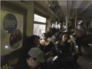  ?? JACKIE FAHERTY — ASSOCIATED PRESS ?? This photo provided by Jackie Faherty from her Twitter page shows subway passengers on an A train with the lights out after it halted just shy of the 125th street stop in New York’s Harlem neighborho­od, Tuesday, June 27, 2017, in New York.